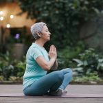 lady sitting on yoga mat in a pose