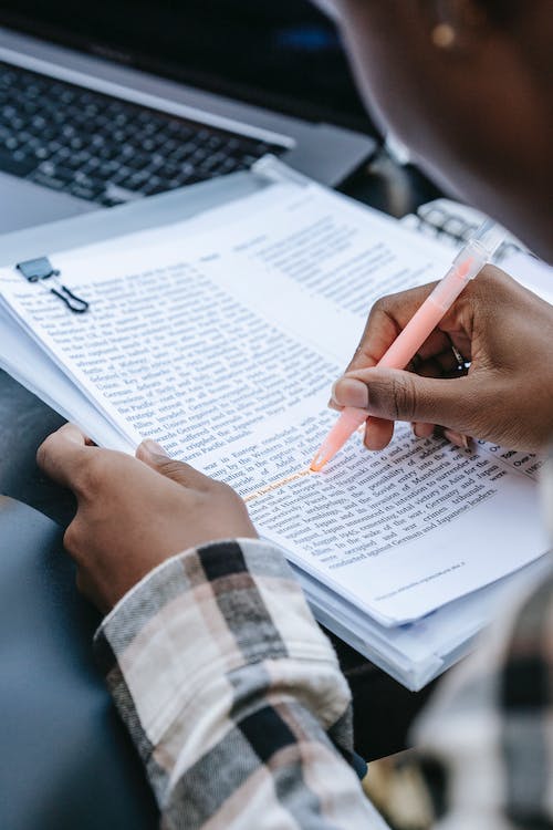person highlighting a report pexels-photo-5965705