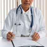 doctor looking at a clipboard. photo credit- pexels-cottonbro-studio-7579827